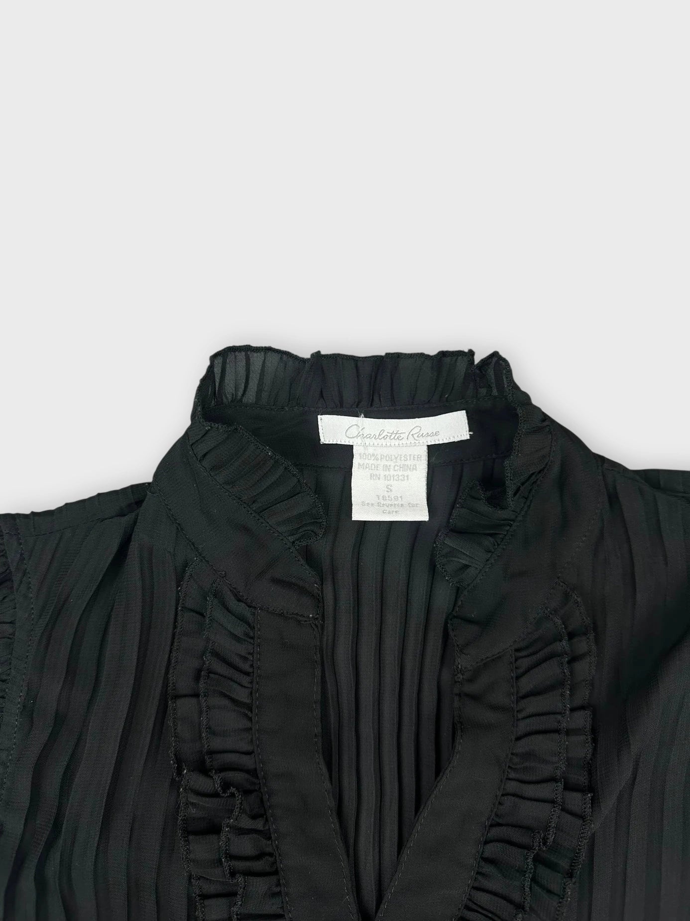 Black button-up top with ruffled collar detail view.