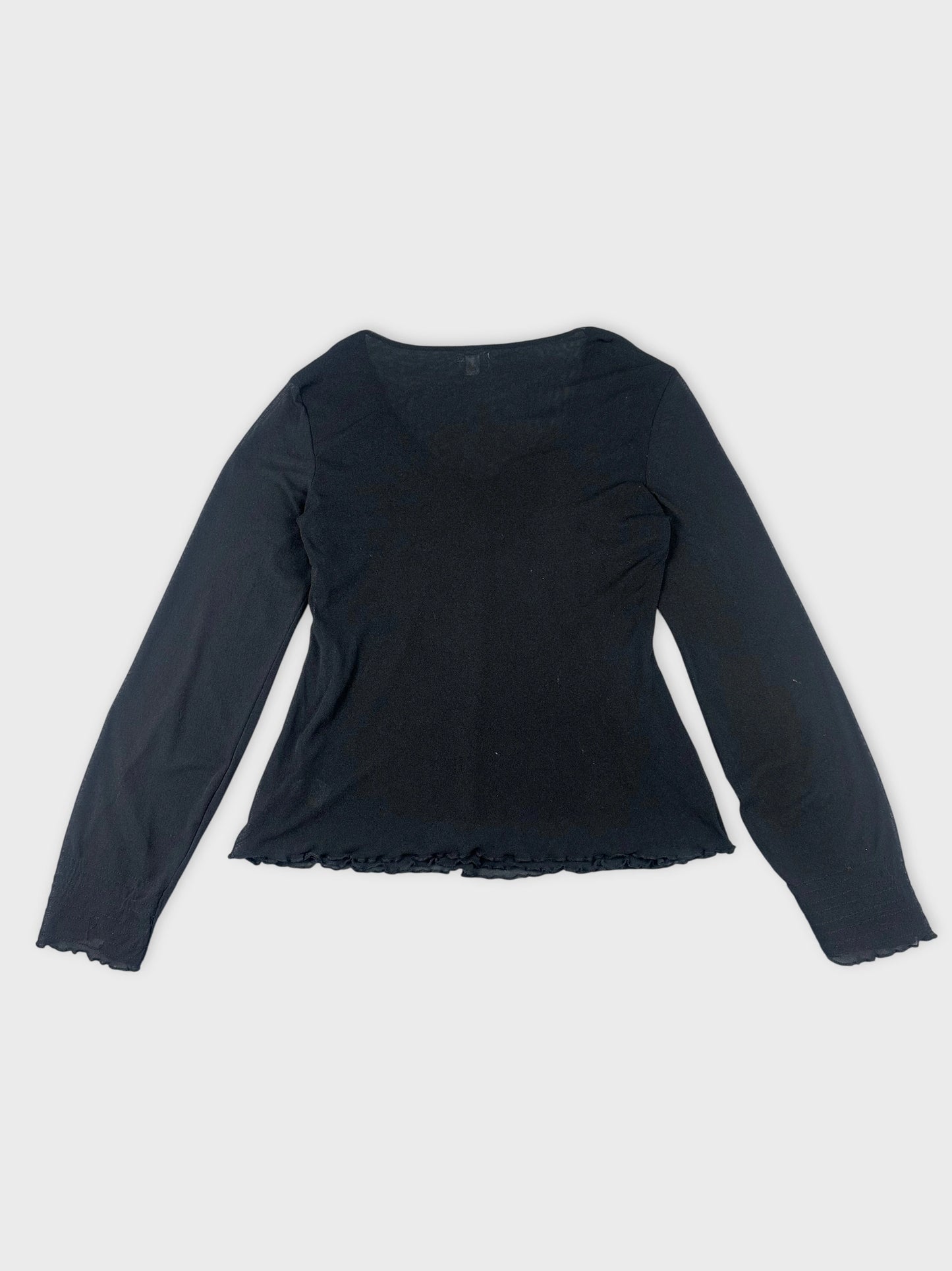 Back view of a black sheer top featuring ruffled hemline.