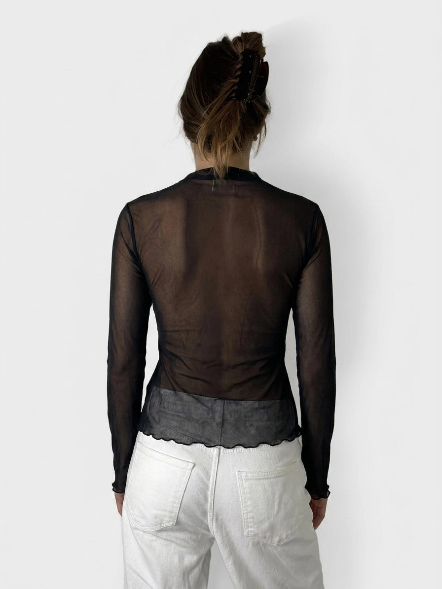 Back view of a black sheer top with scalloped hem detail.