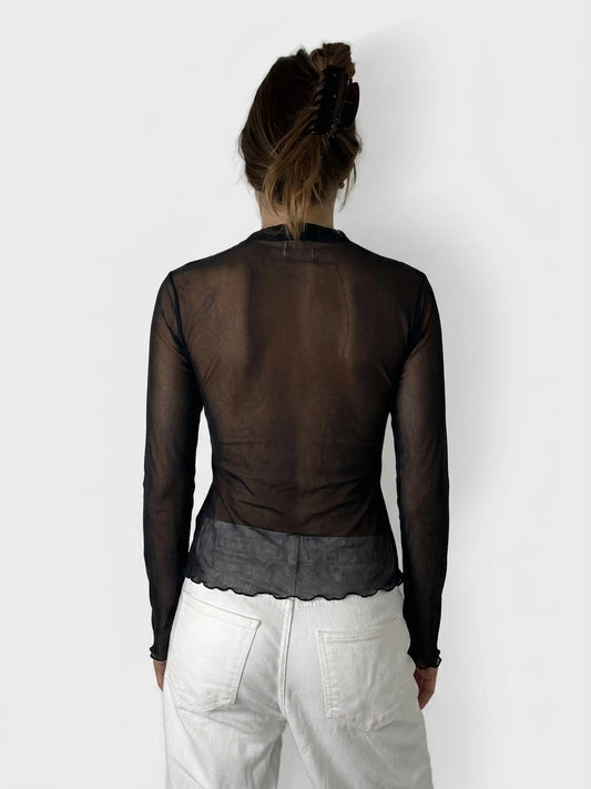 Back view of a black sheer top with scalloped hem detail.
