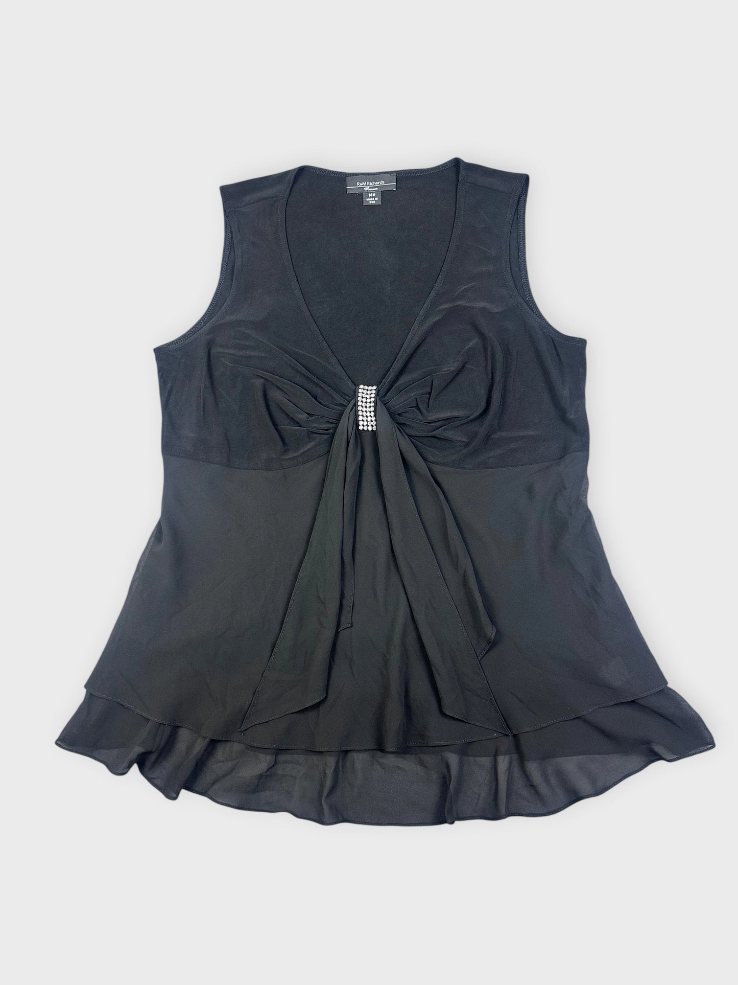 Detail view of a black top featuring a gathered front and a beaded embellishment.