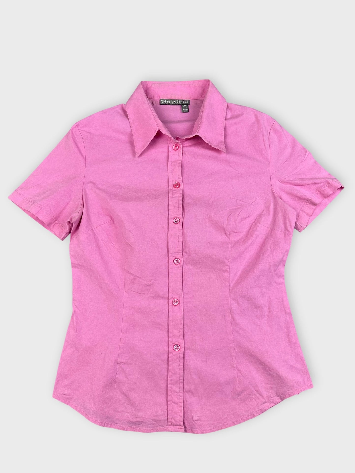 Detail view of a pink cotton top with button closures and collar.