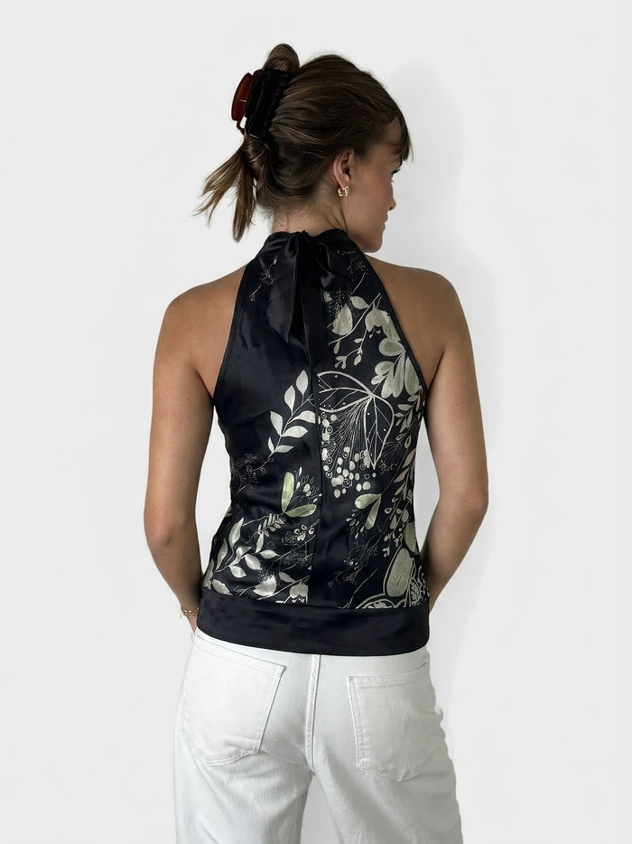Back view of a black satin halter top with floral print detail.