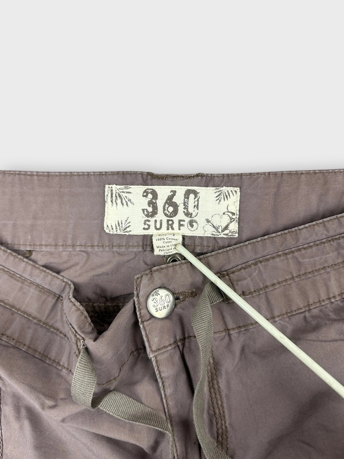 Detail view of a brown mini skirt featuring front pockets and drawstring.