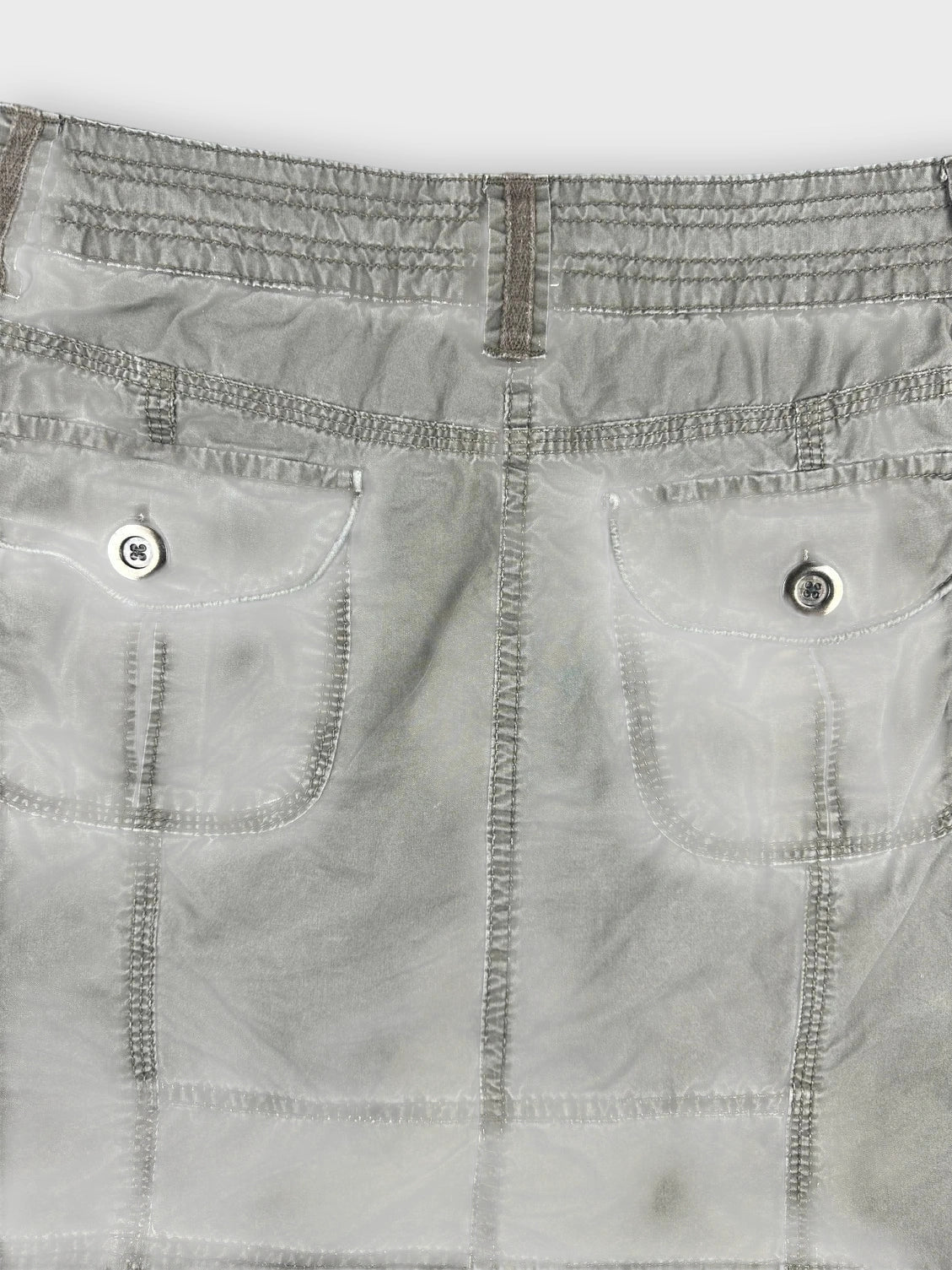 Detail view of an olive mini skirt showcasing smart pockets and structured seams.