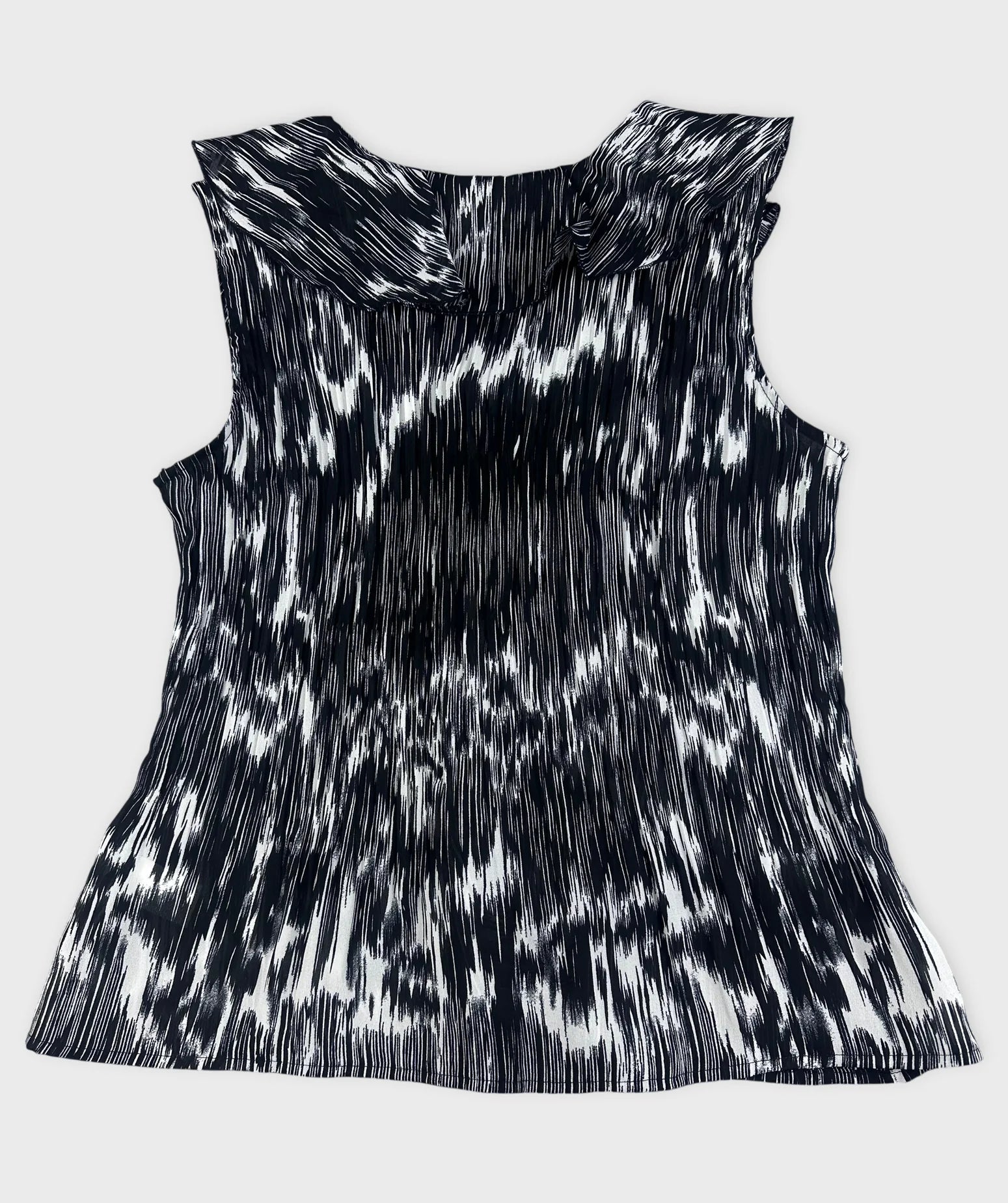 Back view of black and white plissé top with ruffled detail.