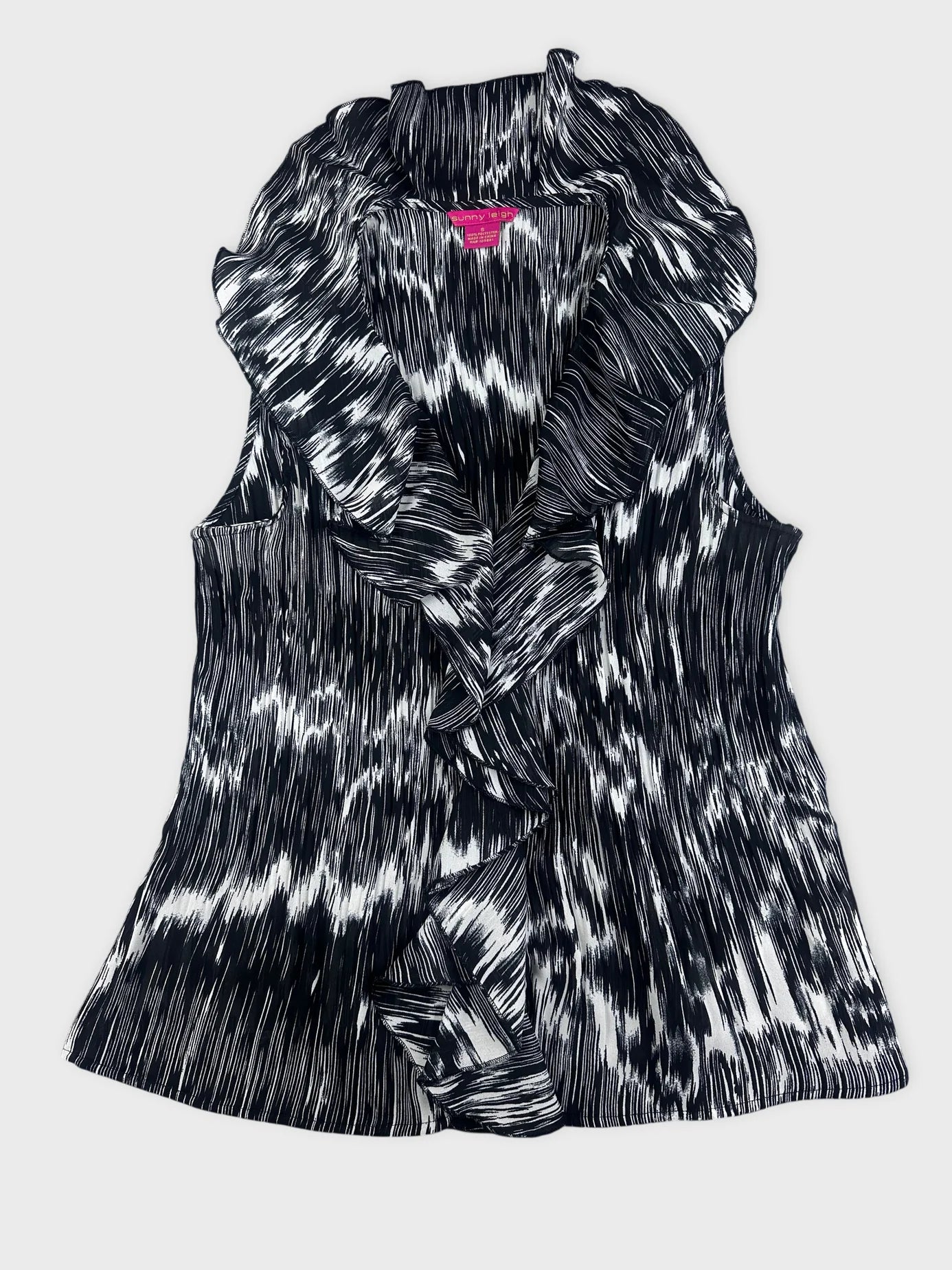 Detail view of a black and white plissé top with ruffled collar