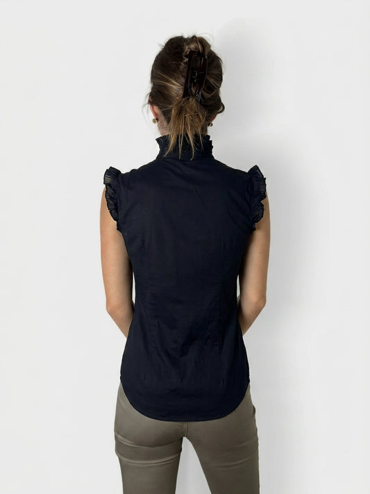 Back view of a black ruffled cotton top with a high collar.