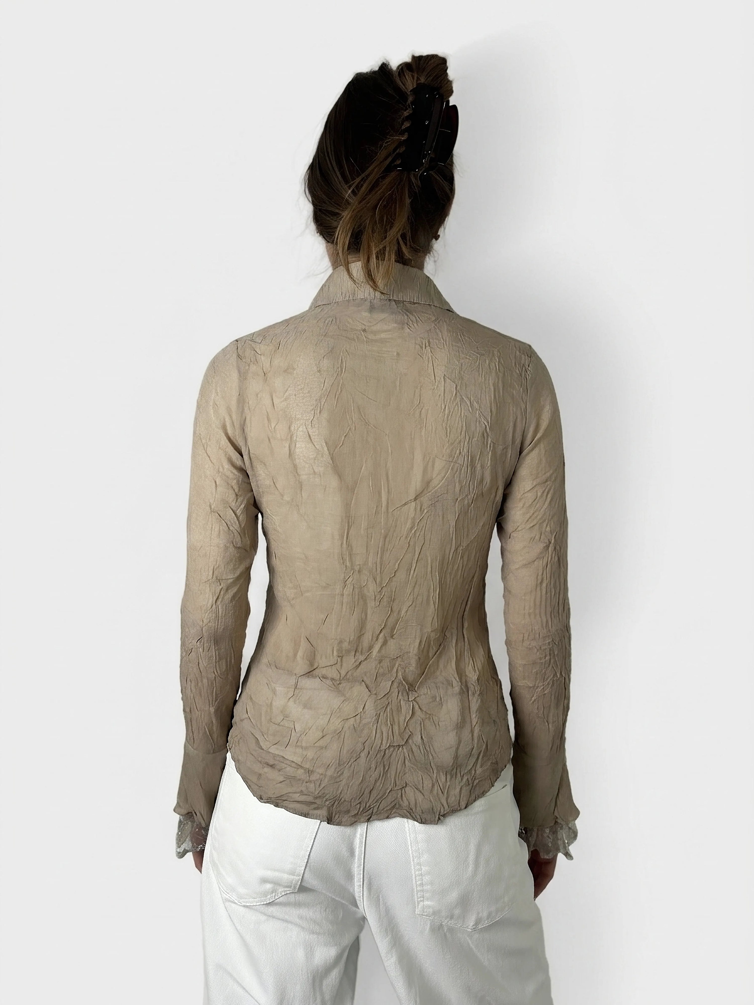 Back view of a beige long sleeve top featuring ruffled cuffs.