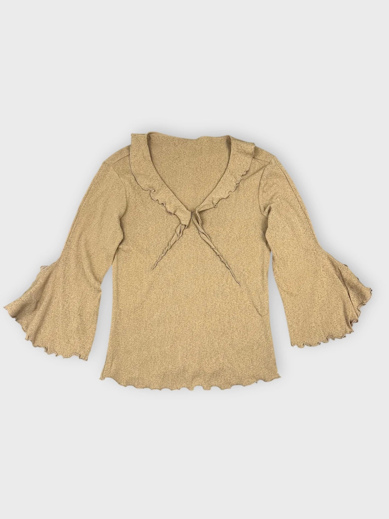 Warm beige long sleeve top with ruffled detail view.