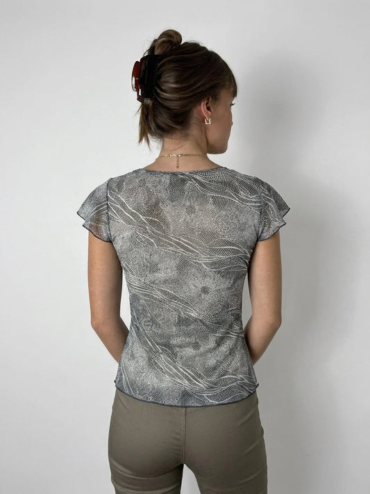 Back view of a chic short sleeve top in gray with flowing wave patterns.