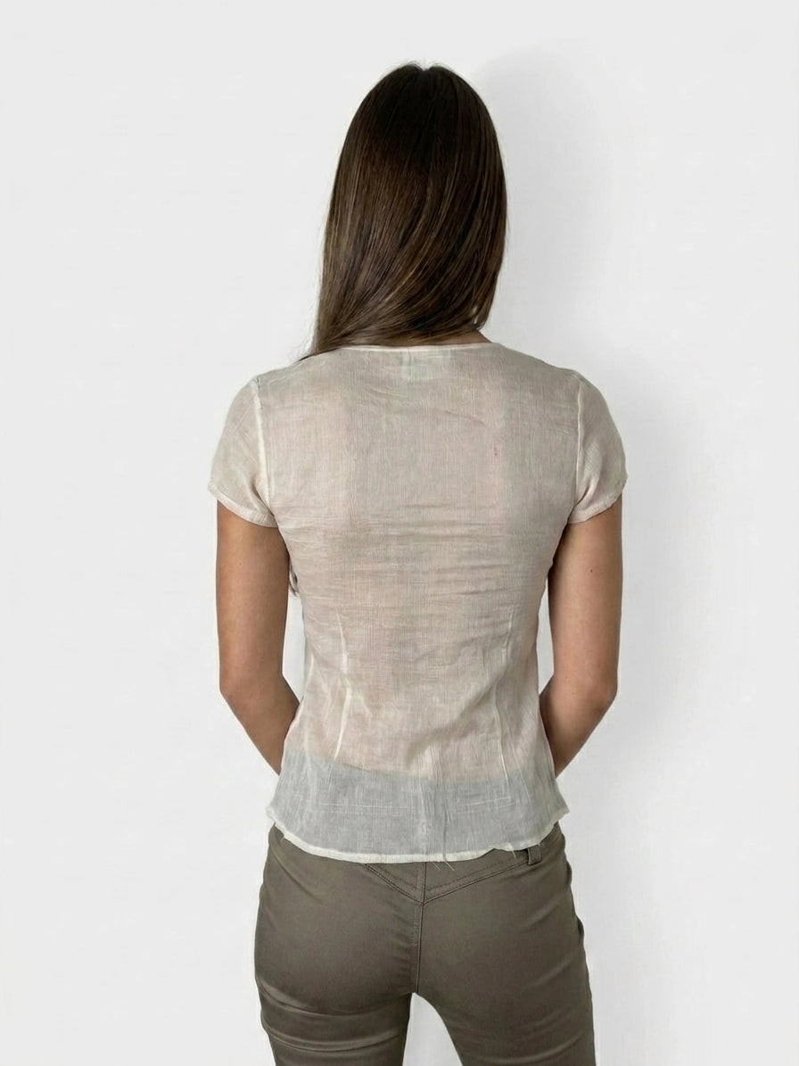 Back view of a chic silk tie-front top in light beige with a smooth texture.