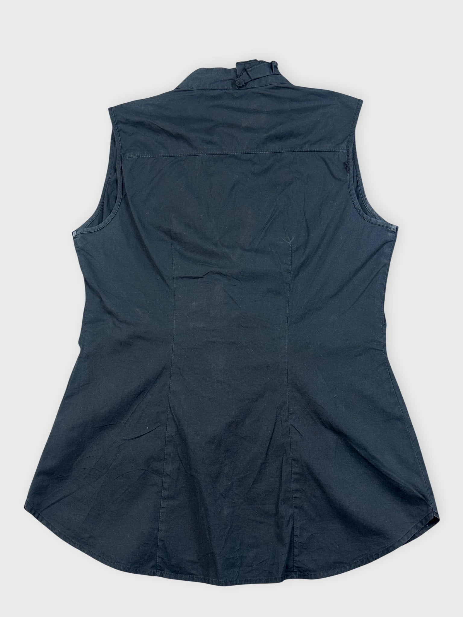 Back view of a black sleeveless ruffled top with a structured design.