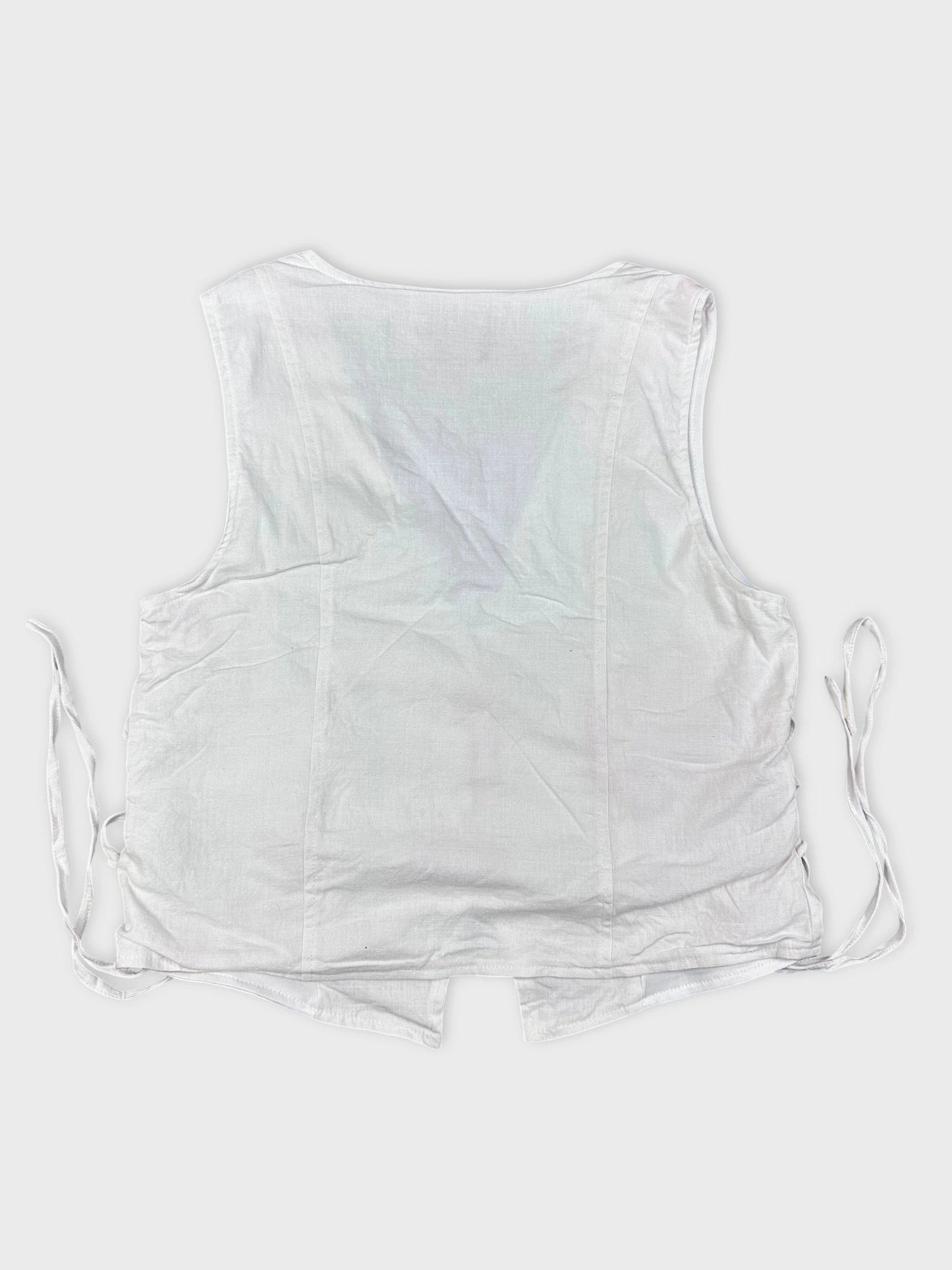 Back view of a white linen top featuring side lace-up detail.