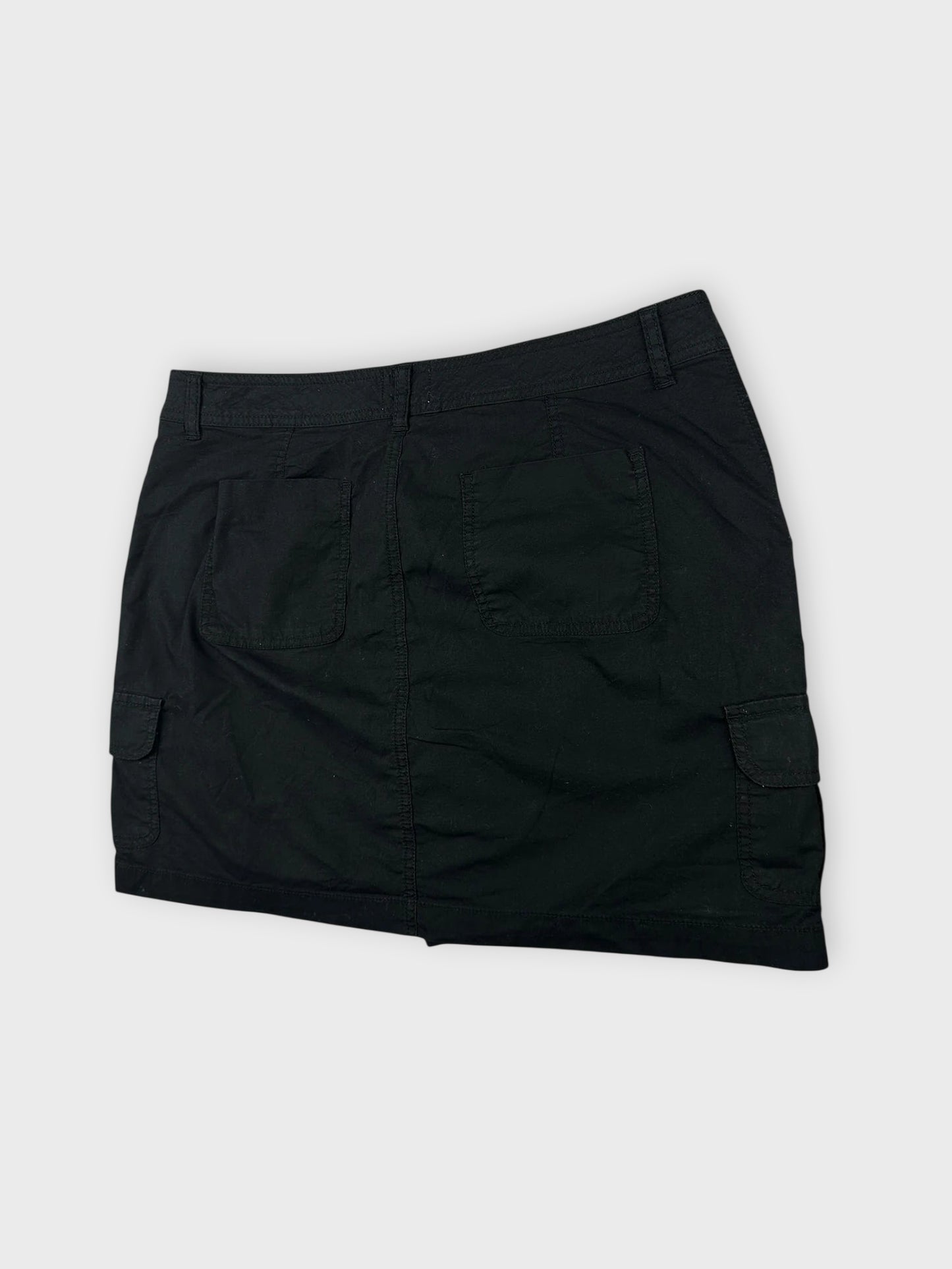 Detail view of black mini cargo shorts featuring side pockets.
