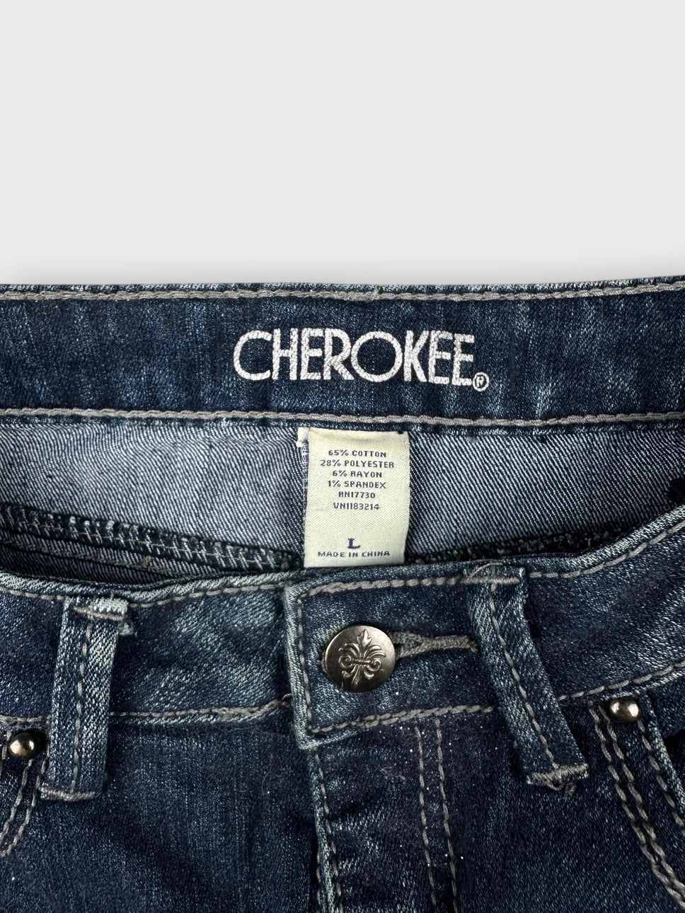 Detail view of a dark blue denim mini skirt with button closure.