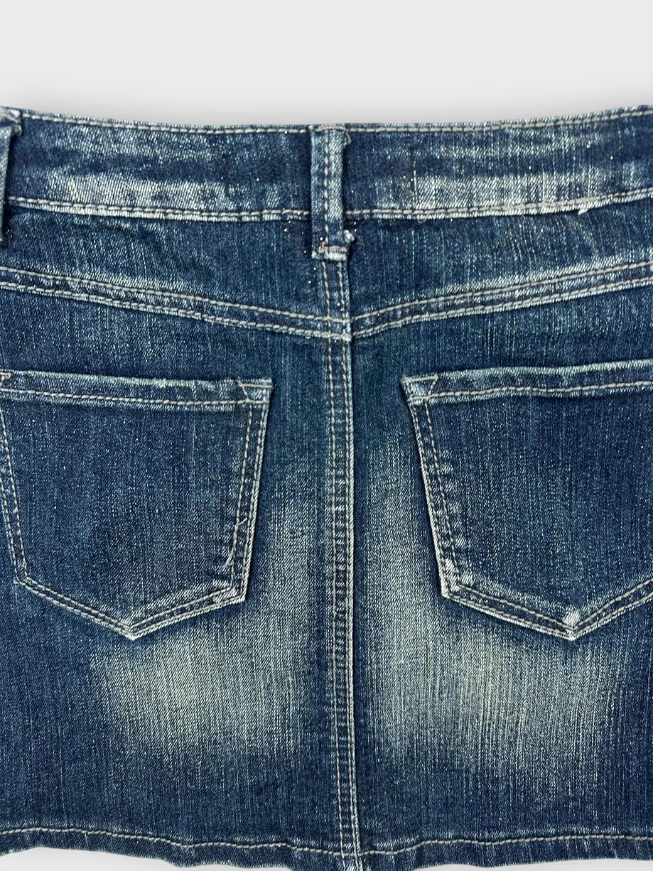 Detail view of a classic denim mini skirt in faded blue with back pockets.