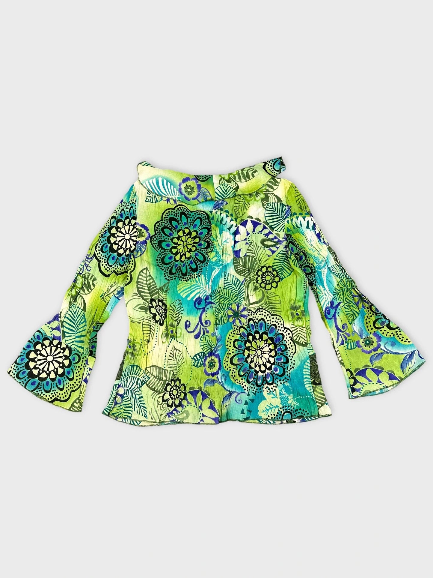 Back view of a colorful floral print blouse in green with ruffled detail.
