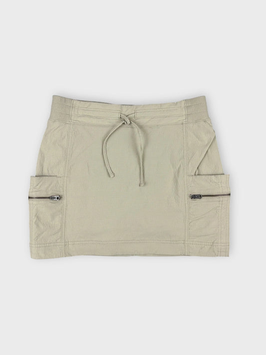 Beige mini skirt with zip pockets in front view.