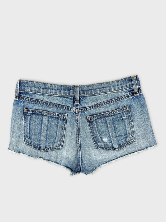 Back view of denim shorts in classic blue with distressed details.
