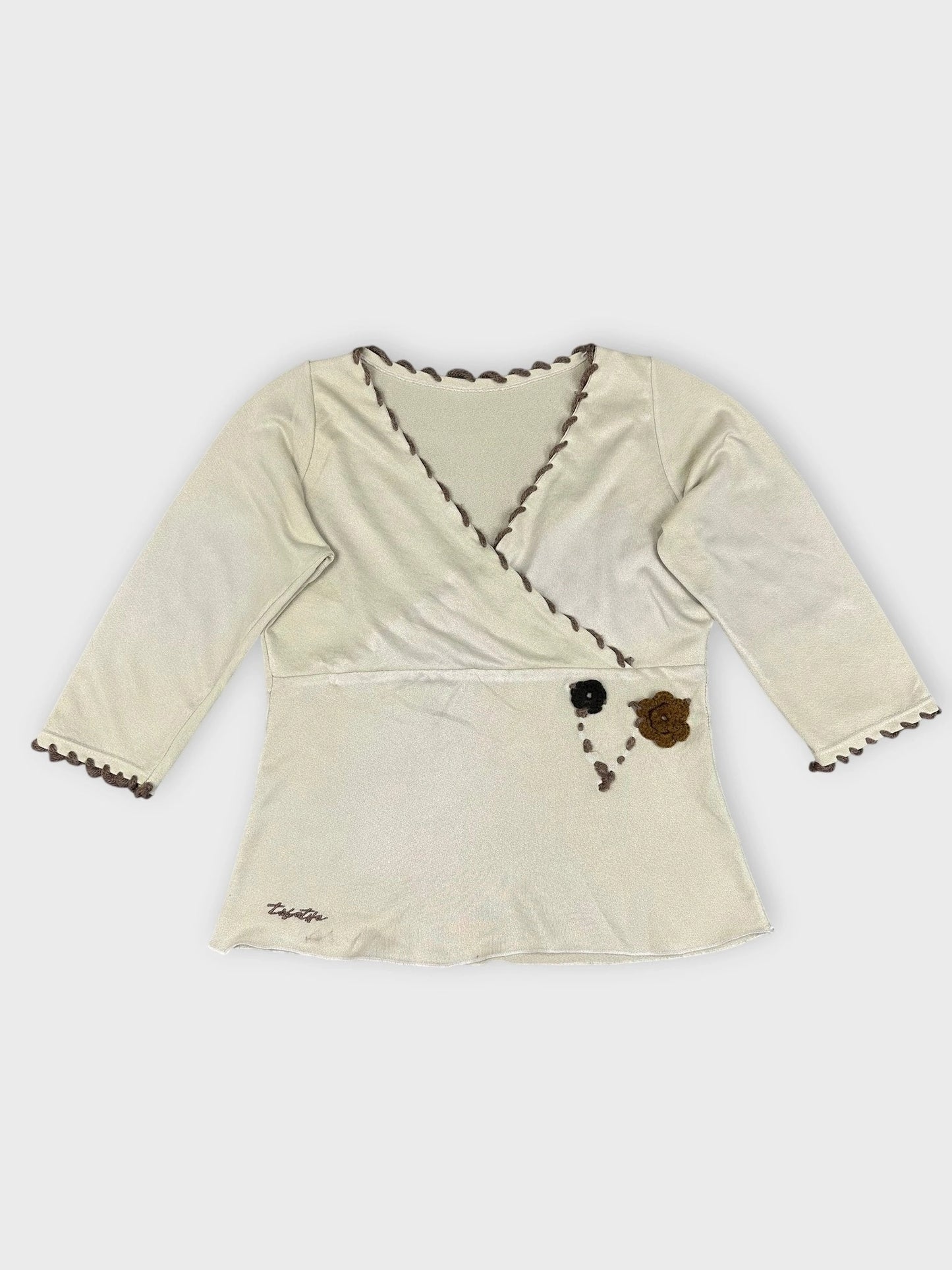 Cream floral wrap top with scalloped edges front view
