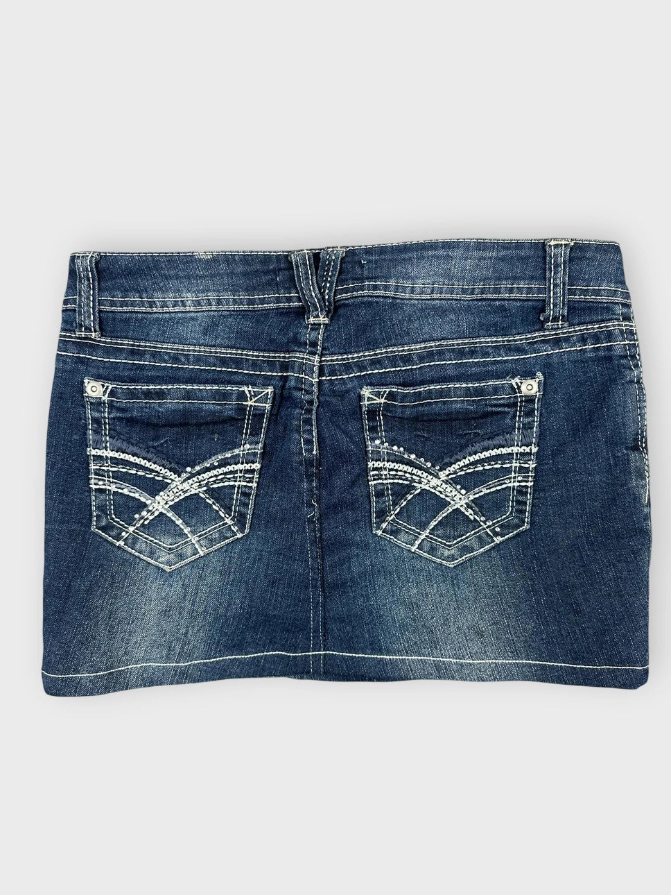 Denim mini skirt back view featuring dark blue color and stitched back pockets.