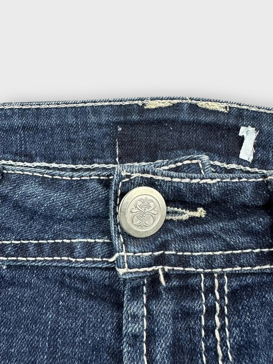 Detail view of dark denim mini skirt with silver button and stitching.