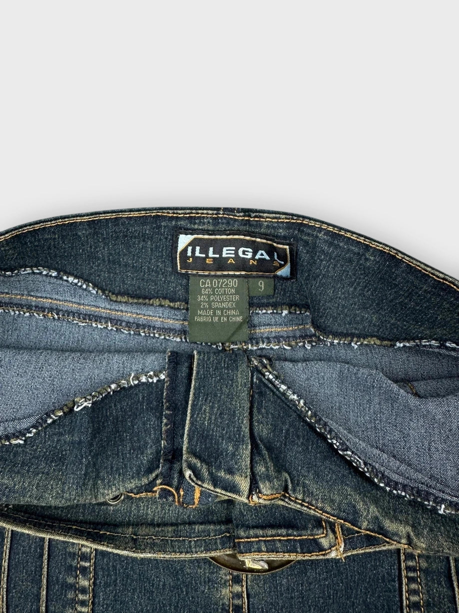 Detail view of a denim mini skirt with belt and pockets, dark blue.