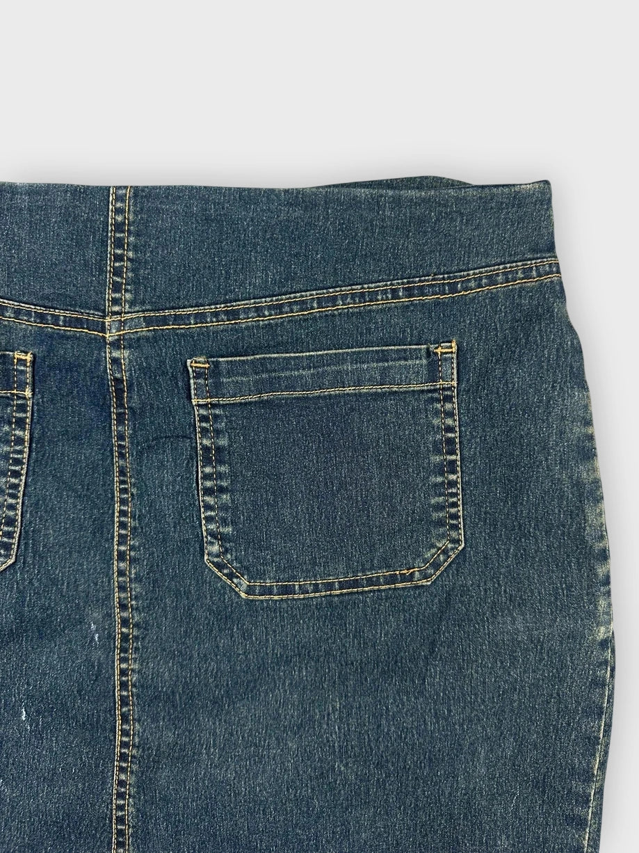 Detail view of a denim mini skirt in blue with back pockets.