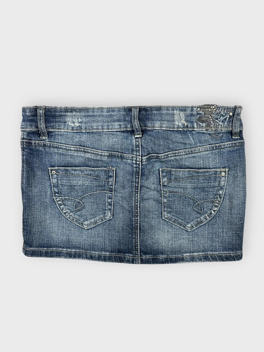 Denim mini skirt back view featuring classic pocket details in blue.