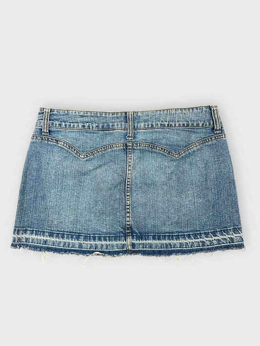 Denim mini skirt in light blue back view with frayed hem detail.