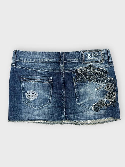 Denim mini skirt in dark blue with distressed details back view.
