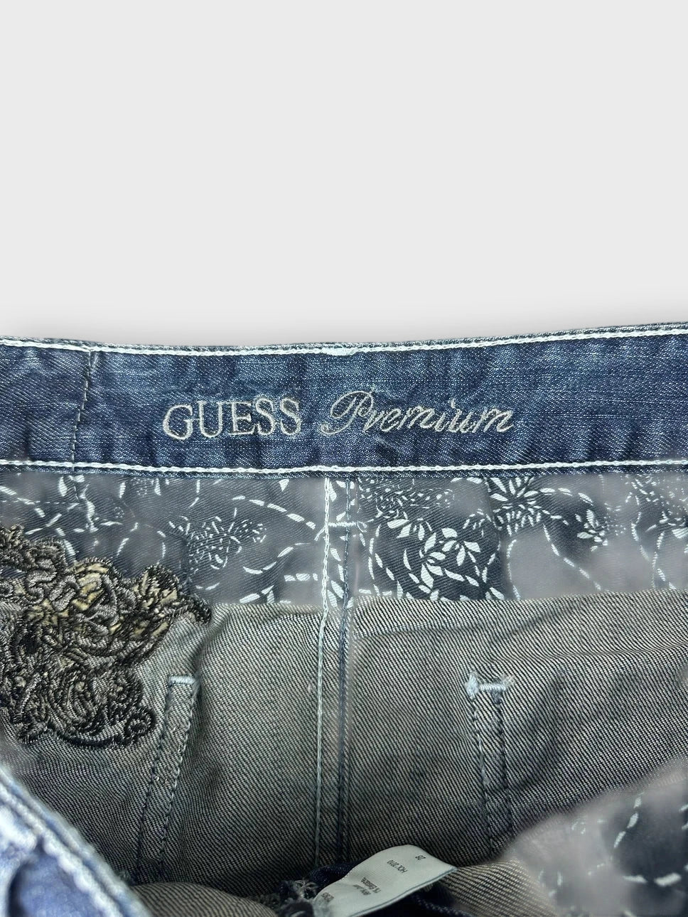 Detail view of denim mini skirt with dark blue and floral lining pattern.