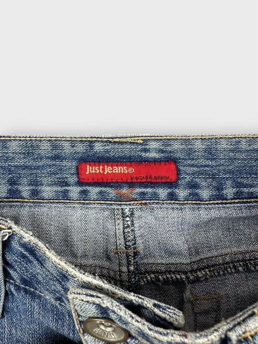 Detail view of a denim mini skirt in light blue with logo tag.
