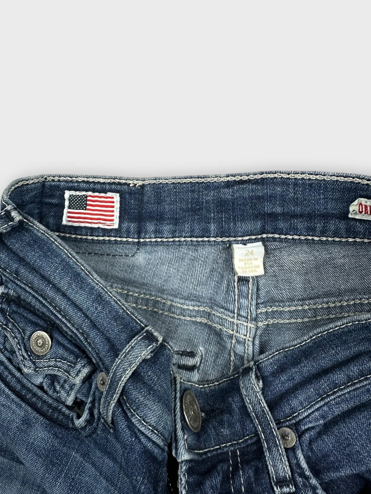Detail view of denim shorts in classic blue with frayed edges.