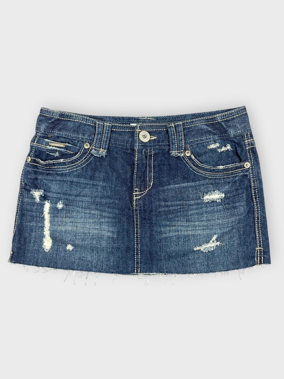 Distressed denim mini skirt in navy front view featuring a frayed hem.