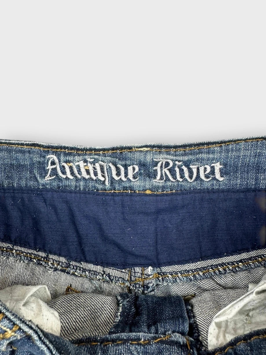 Detail view of distressed denim mini skirt with studs in blue.