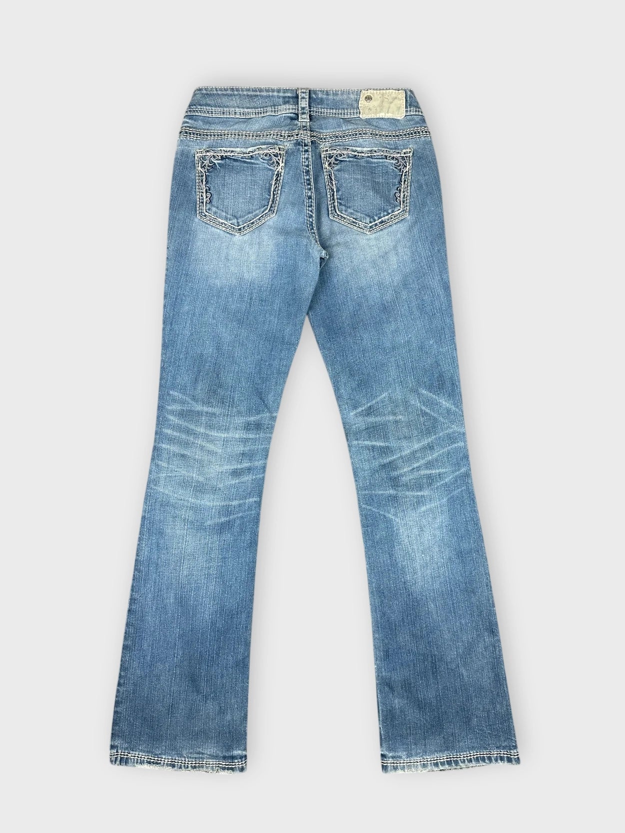 Distressed light blue denim jeans back view with detailed pockets and worn look.
