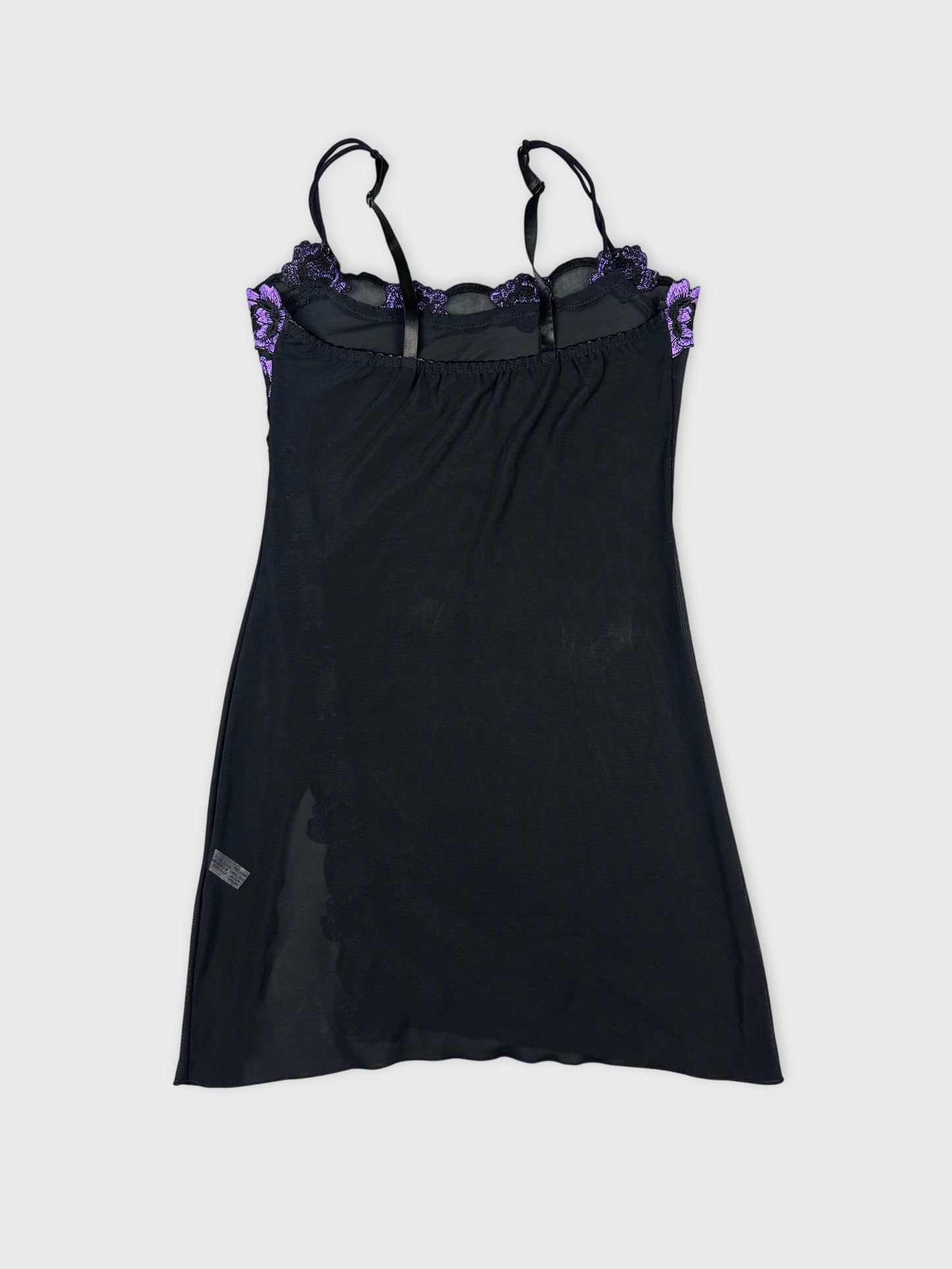 Back view of a black mesh tank top featuring purple floral trim.