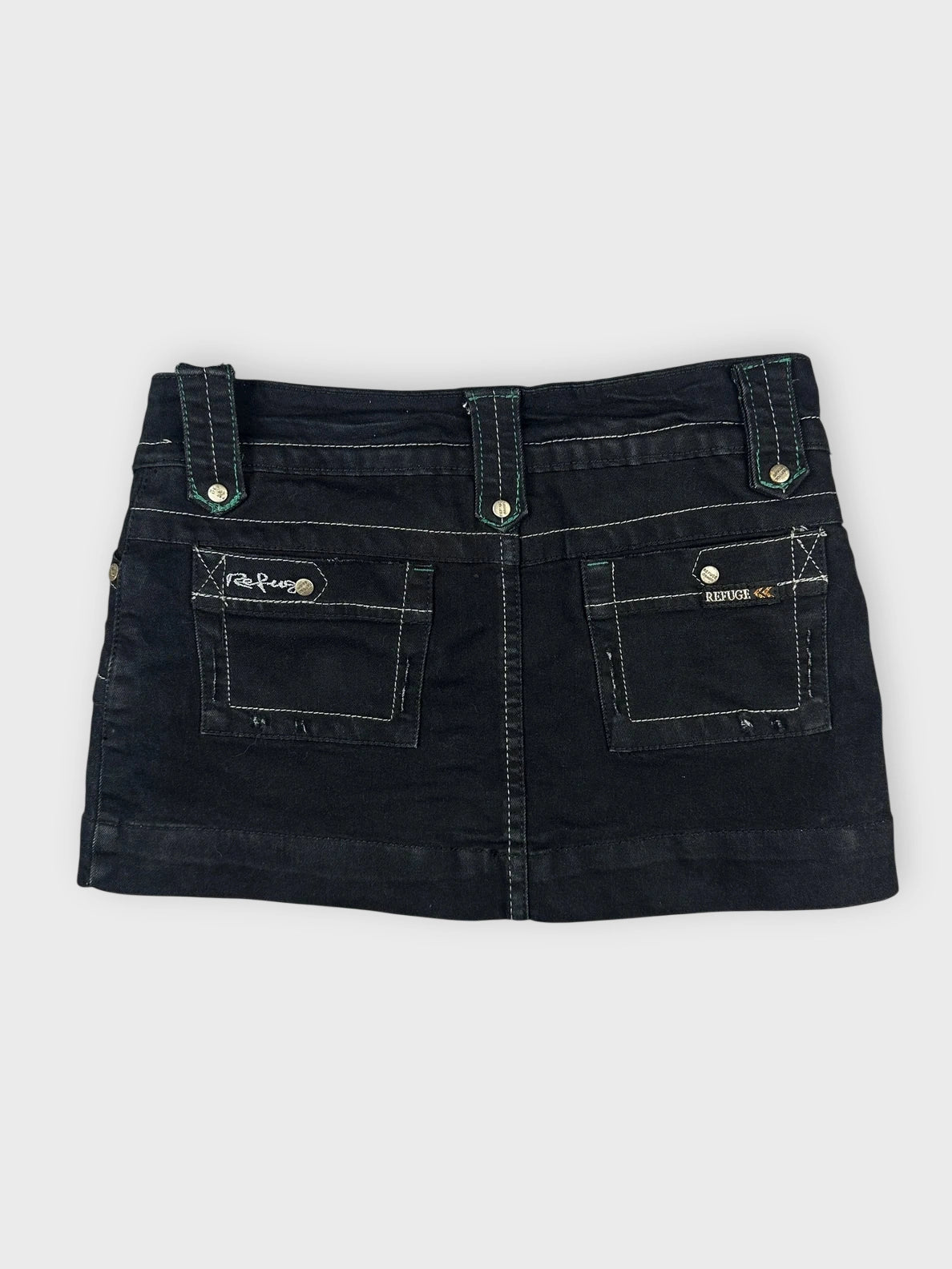 Back view of an edgy black mini skirt with pockets and visible stitching.