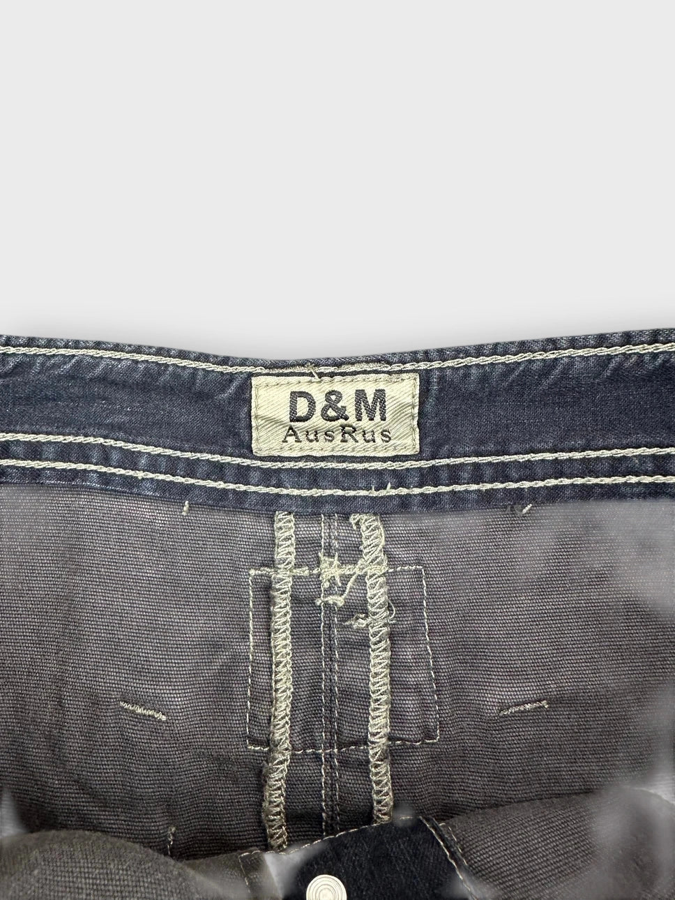 Detail view of a dark denim mini skirt with ruffled edges.