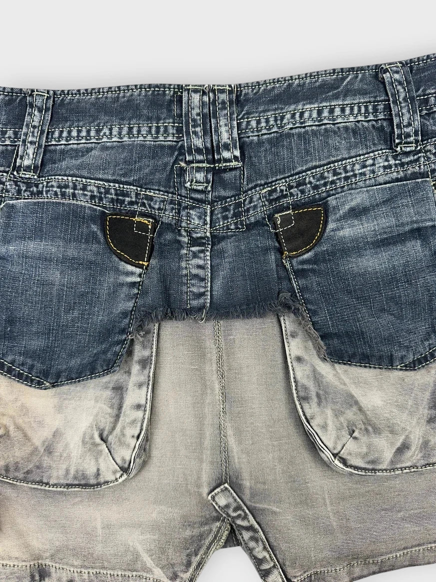 Detail view of an edgy denim mini skirt with ruffles in blue.