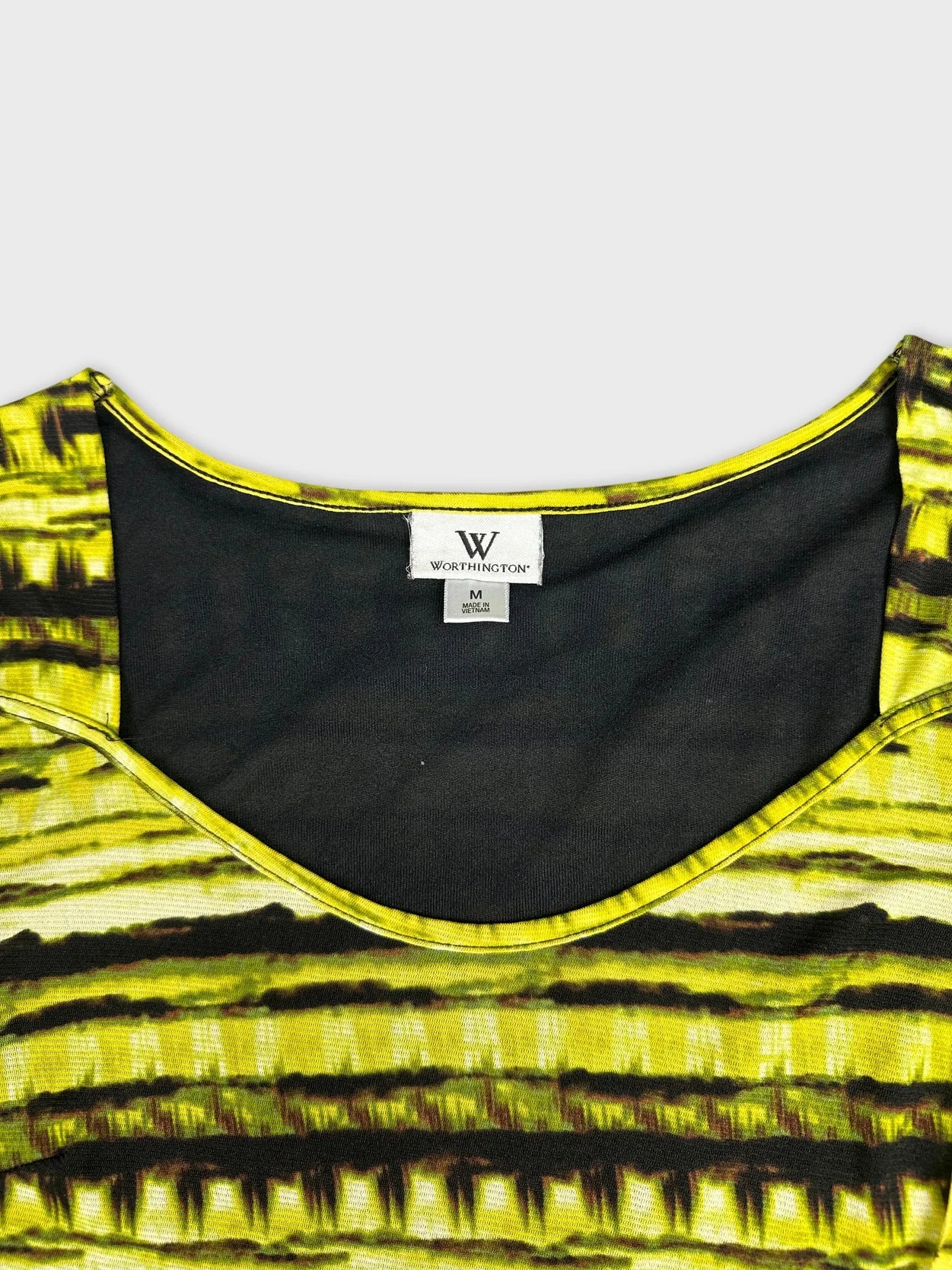 Detail view of an edgy green top with a bold striped pattern.