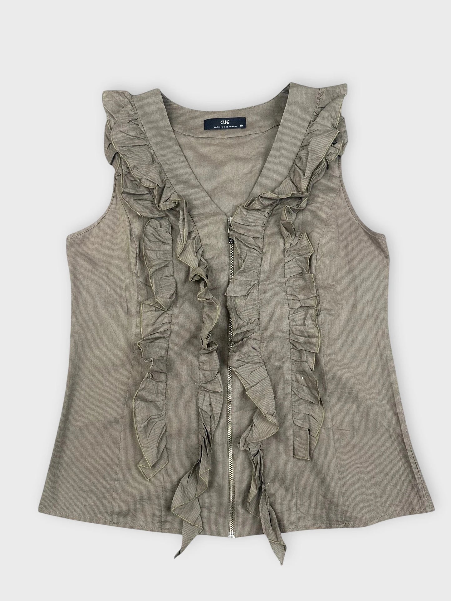 Detail view of a green ruffle zip top featuring layered ruffles.