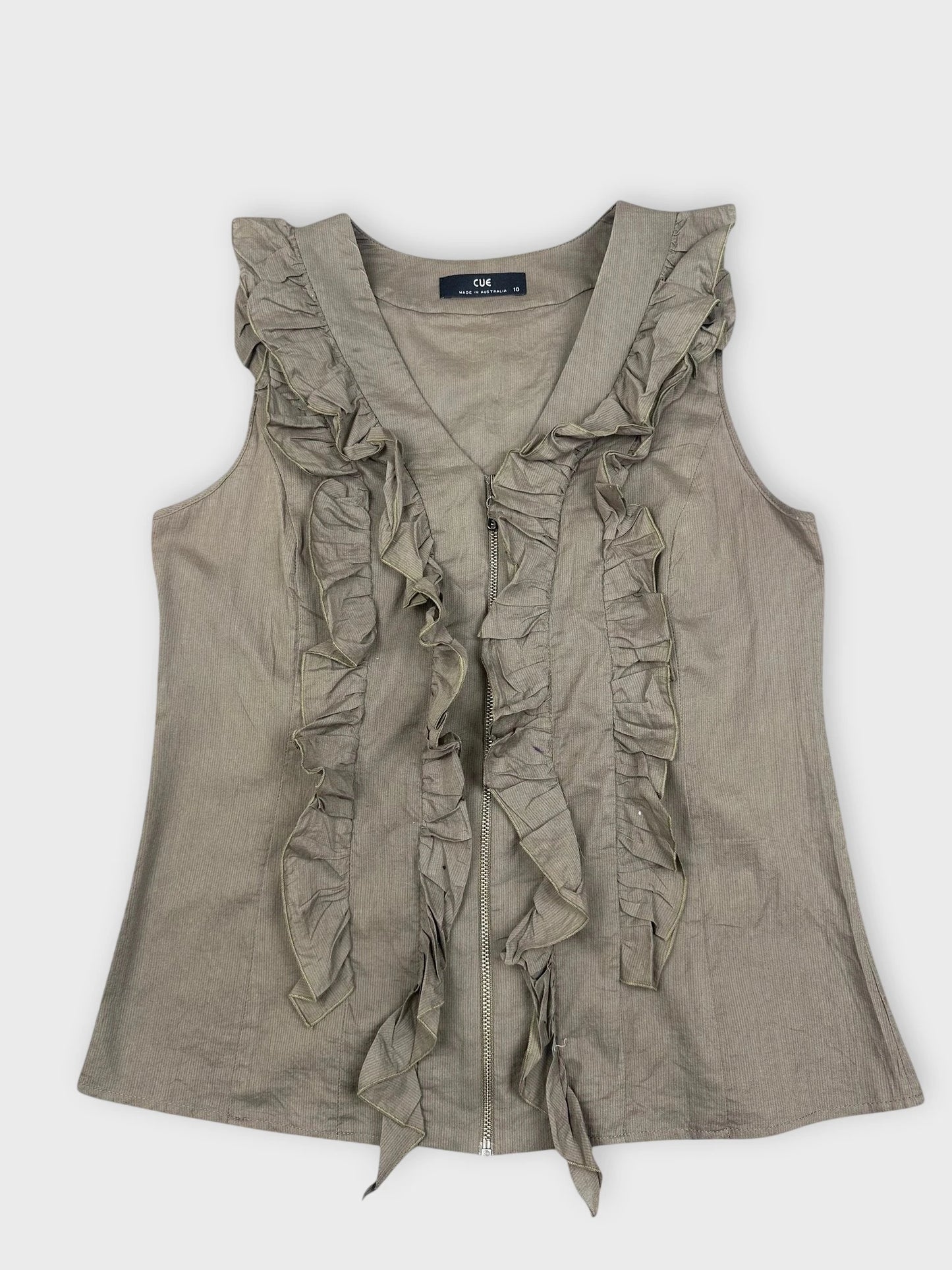 Front view of green ruffle zip top featuring loose ruffles along the zipper.