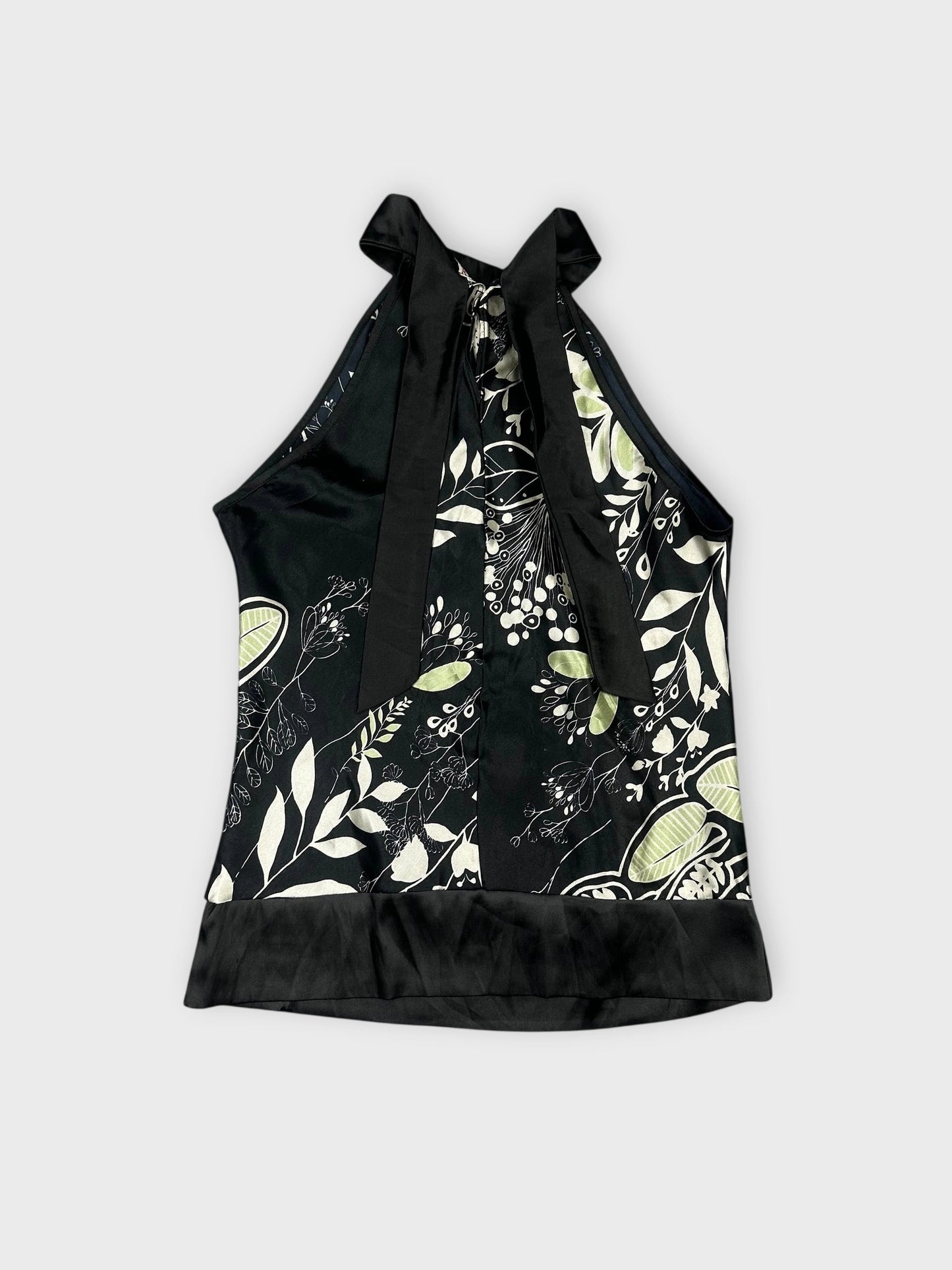 Back view of a floral satin halter top in black with green print.