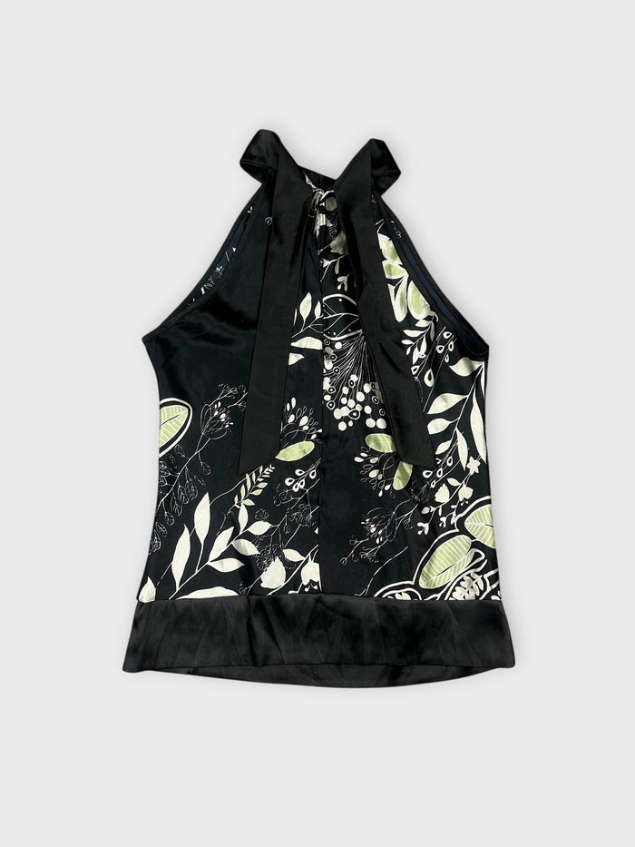 Back view of a floral satin halter top in black with green print.