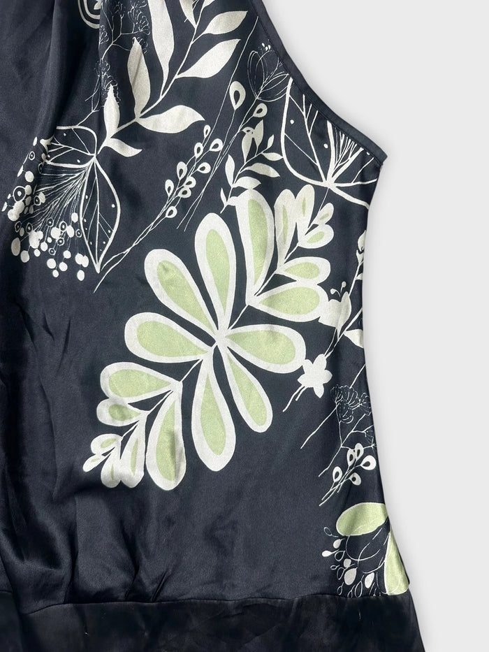 Detail view of floral satin halter top in black with green patterns
