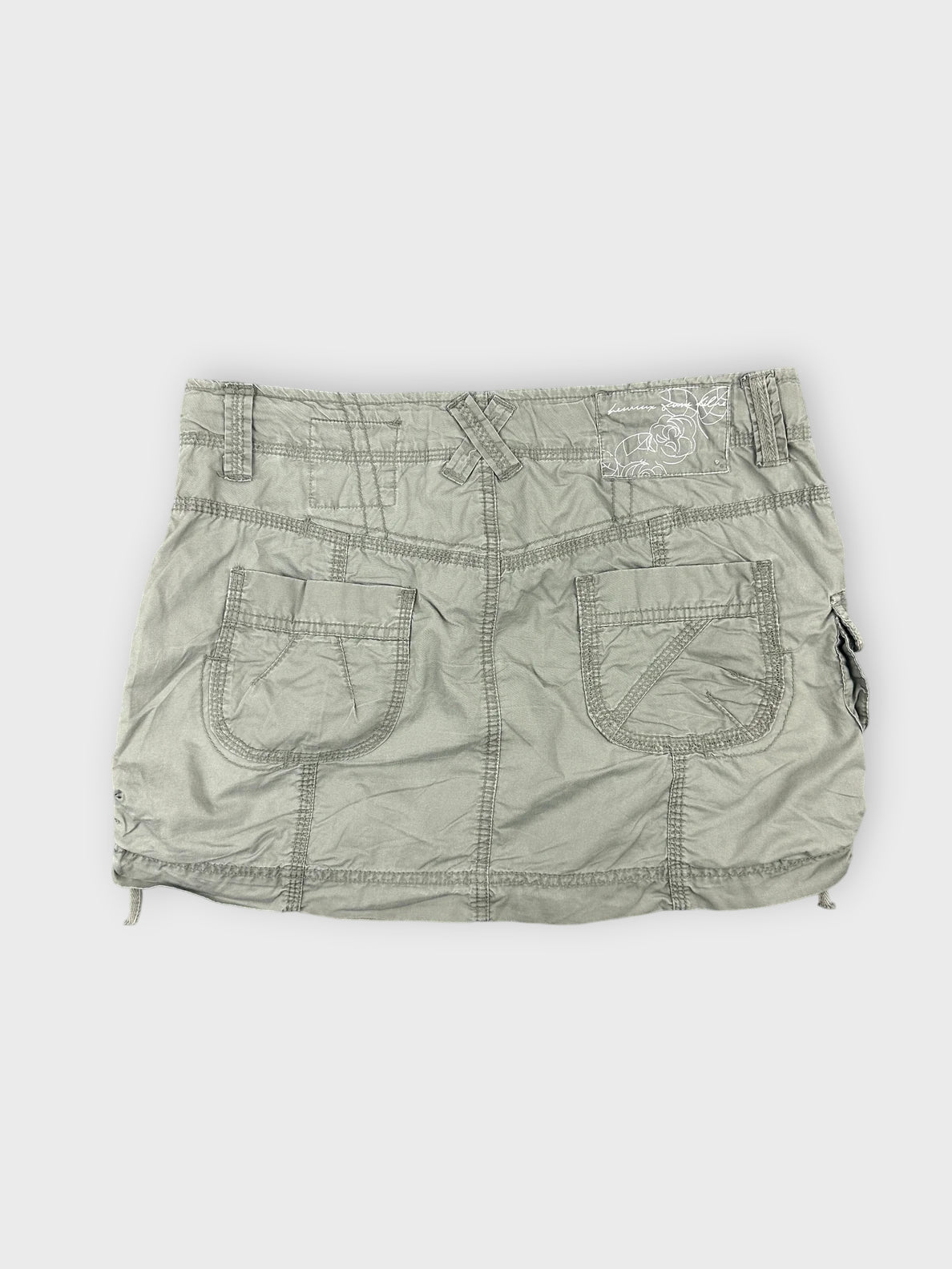 Faded green mini skirt with pocket details back view.