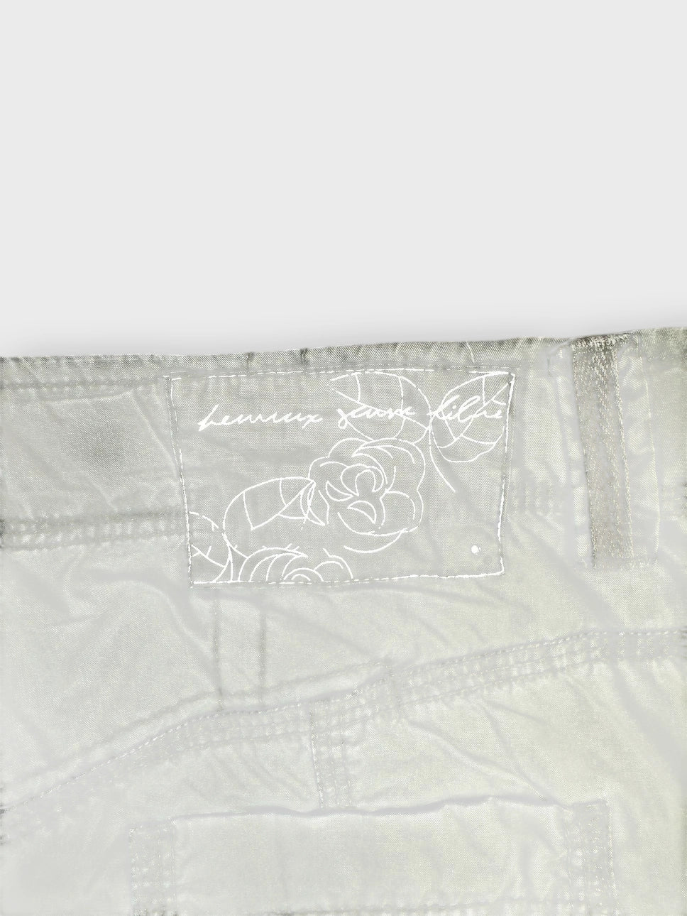 Detail view of faded green mini skirt showing pocket details and tag